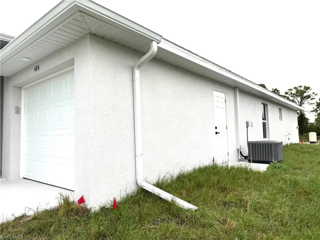 View of property exterior featuring a garage and central air condition unit
