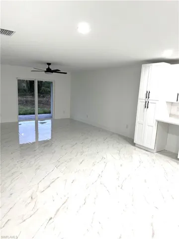 Unfurnished living room featuring ceiling fan