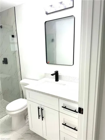 Bathroom with vanity, toilet, and a tile shower