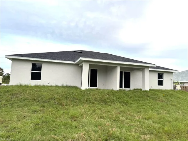 Rear view of property featuring a lawn