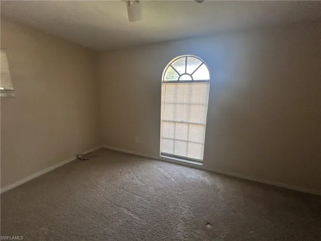 Carpeted empty room with baseboards