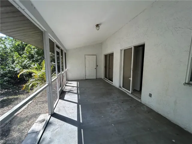 Unfurnished sunroom featuring vaulted ceiling