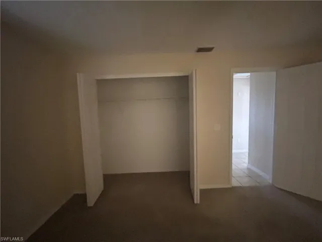 Unfurnished bedroom featuring a closet and light colored carpet