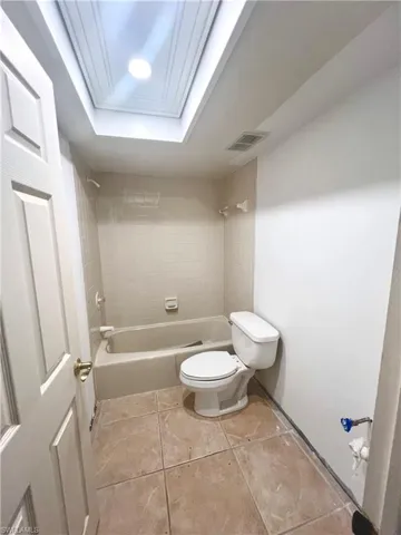 Bathroom, toilet, and tiled shower / bath combo