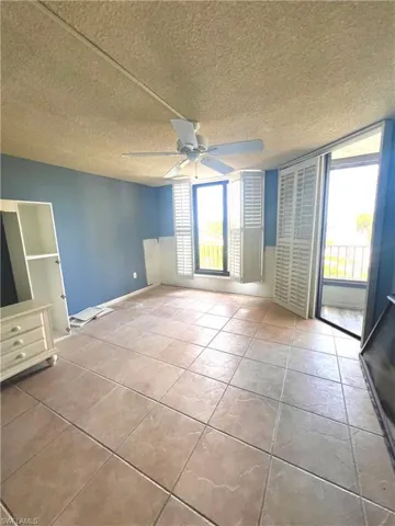 Large Master bedroom featuring a textured ceiling and ceiling fan