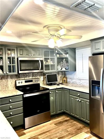 Kitchen featuring wood ceiling, ceiling fan, light wood-type flooring, and stainless steel appliances