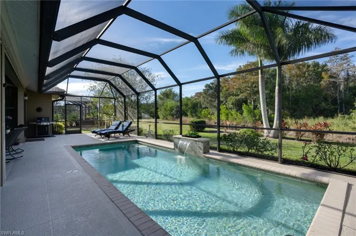 Outdoor pool featuring a sunroom, a lanai, grilling area, and a patio
