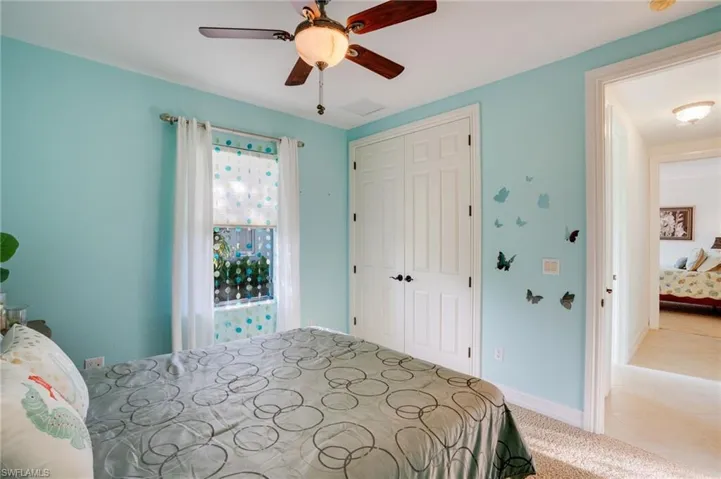 Bedroom with carpet, a closet, and a ceiling fan