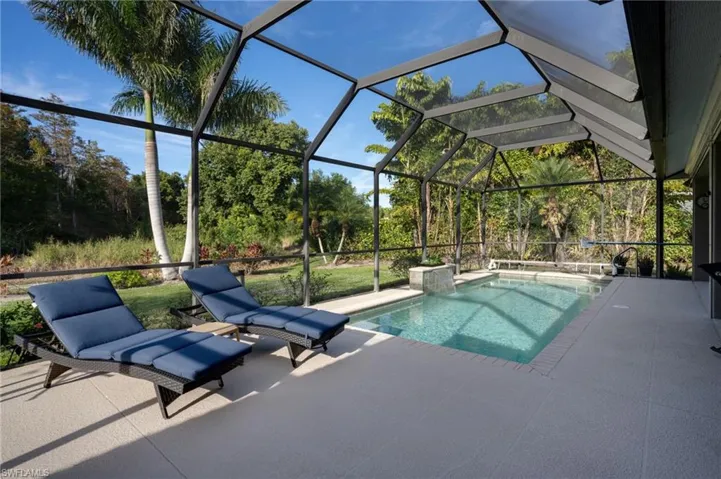Outdoor pool with a lanai, a sunroom, and a patio area