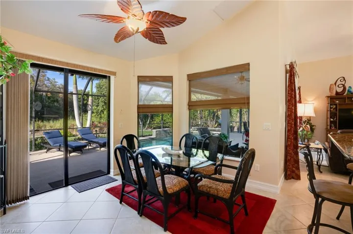 Dining area featuring light tile patterned floors, lofted ceiling, plenty of natural light, a sunroom, and a ceiling fan