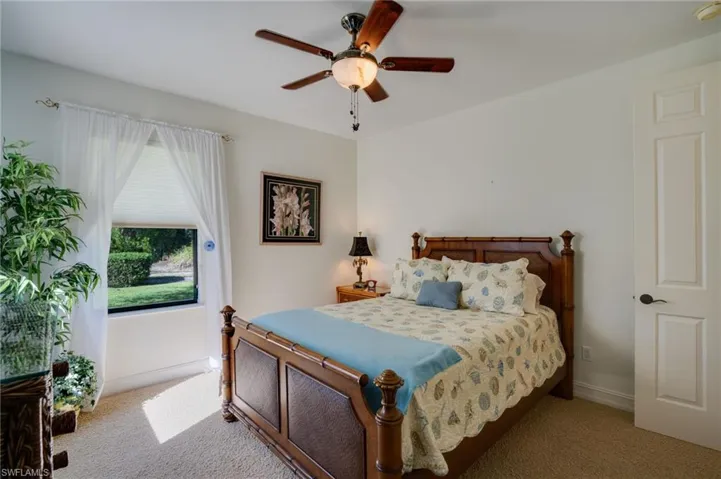 Carpeted bedroom with baseboards and a ceiling fan