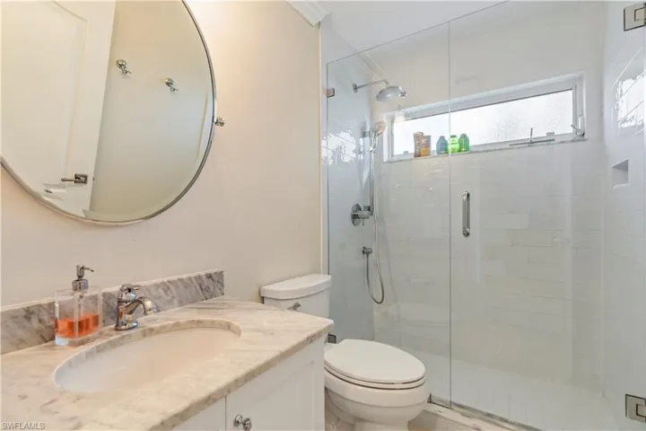 Full bath featuring toilet, vanity, and a shower stall