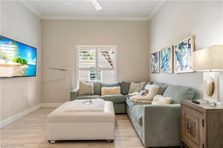 Living room featuring baseboards, light wood-style flooring, and crown molding