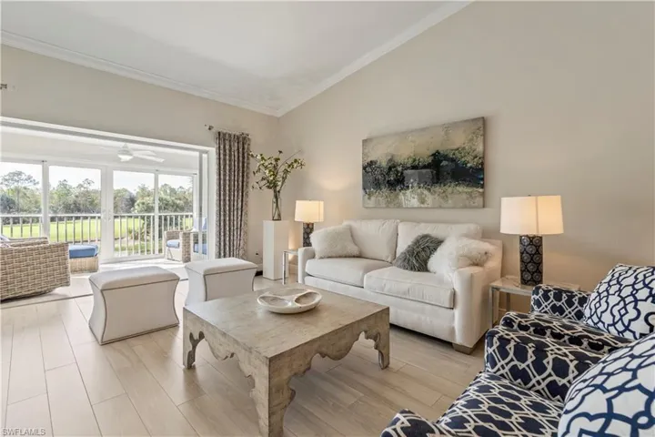 Living room featuring light wood-style floors, ceiling fan, and ornamental molding