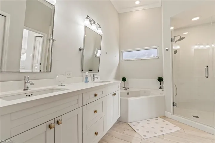 Full bathroom with a bath, ornamental molding, a sink, and a shower stall