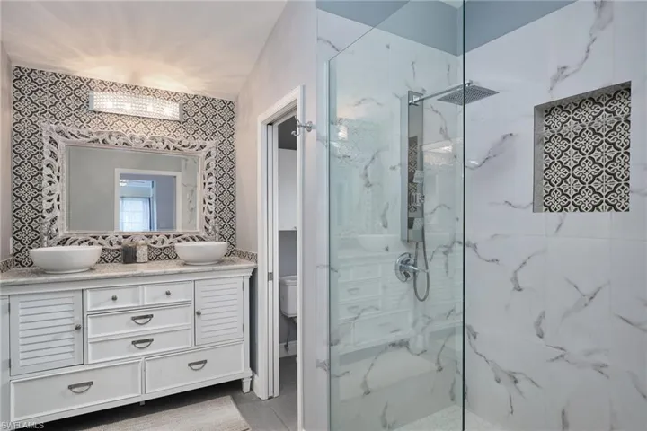 Bathroom with vanity, toilet, and a shower with shower door