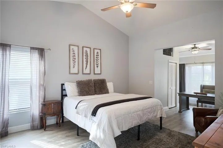 Bedroom with hardwood / wood-style flooring, ceiling fan, a closet, and vaulted ceiling