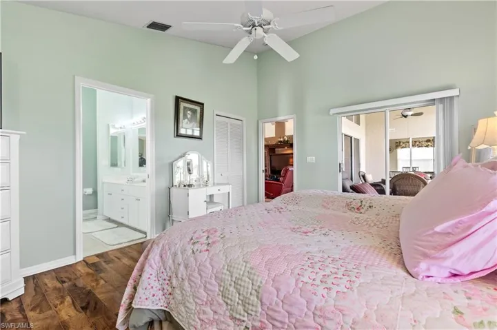 Bedroom with wood finished floors, access to outside, ceiling fan, a closet, and ensuite bathroom
