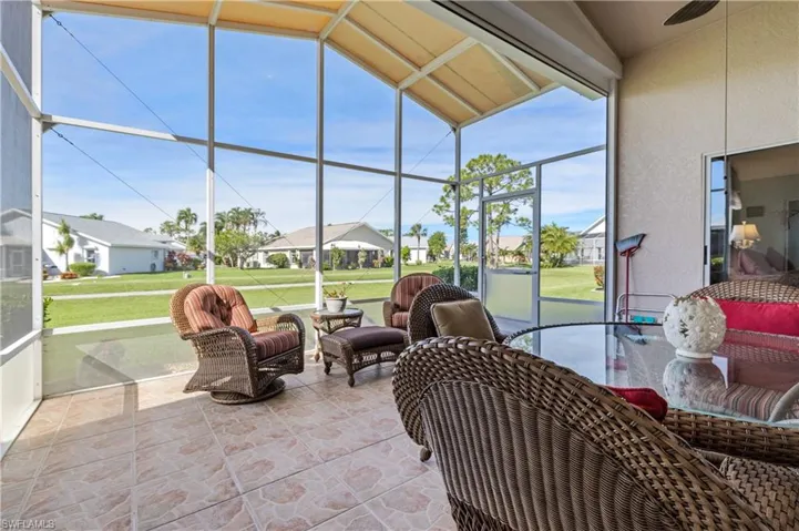 Sunroom / solarium featuring a residential view, a patio area, and a ceiling fan