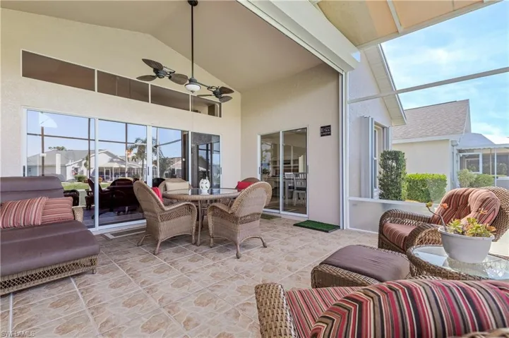 View of patio featuring a sunroom, a ceiling fan, and an outdoor living space