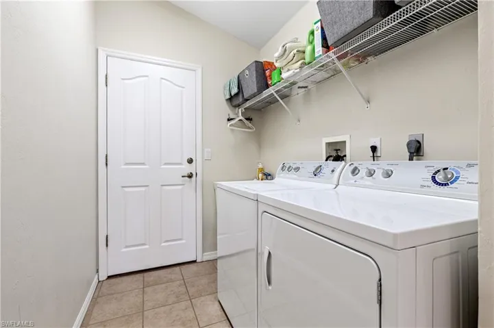 Laundry area featuring light tile patterned flooring and independent washer and dryer