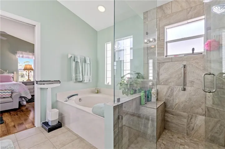 Ensuite bathroom with a shower stall, tile patterned flooring, a bath, and recessed lighting
