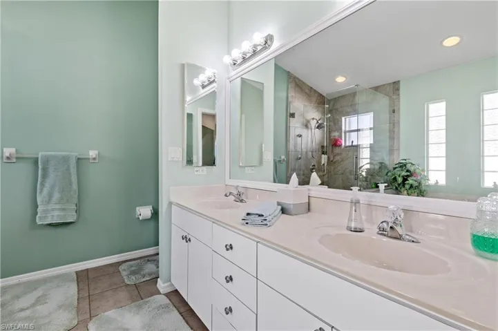 Full bath featuring light tile patterned floors, double vanity, a stall shower, and recessed lighting
