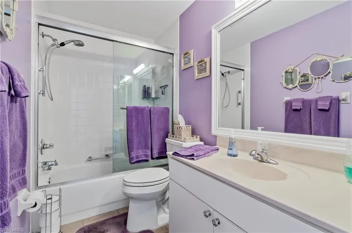 Full bath featuring vanity, combined bath / shower with glass door, and tile patterned floors