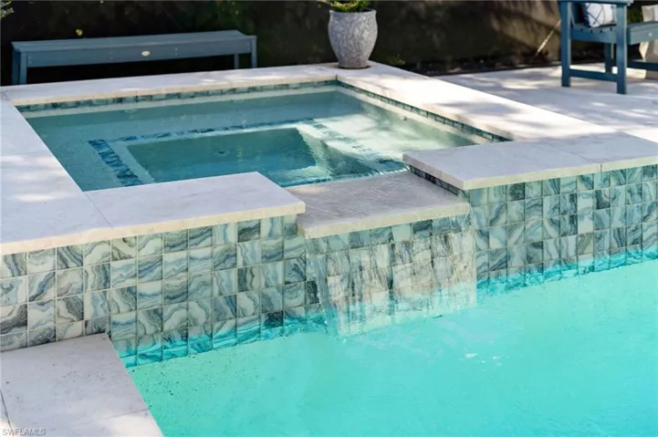 Swimming pool featuring an in-ground hot tub and a patio area