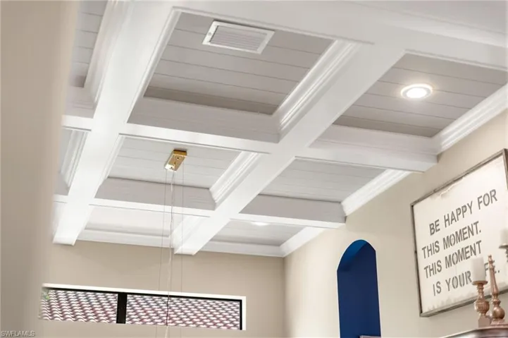 Detailed view of beamed ceiling, coffered ceiling, and crown molding