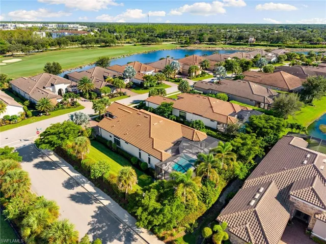 Aerial view of residential area featuring a large body of water and a local golf course