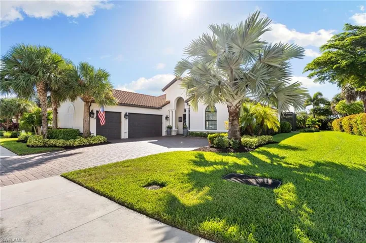 Mediterranean / spanish-style home featuring an attached garage, decorative driveway, a front lawn, and stucco siding