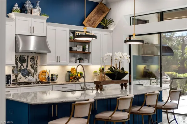 Bar with blue cabinets, white cabinetry, open shelves, under cabinet range hood, and tasteful backsplash
