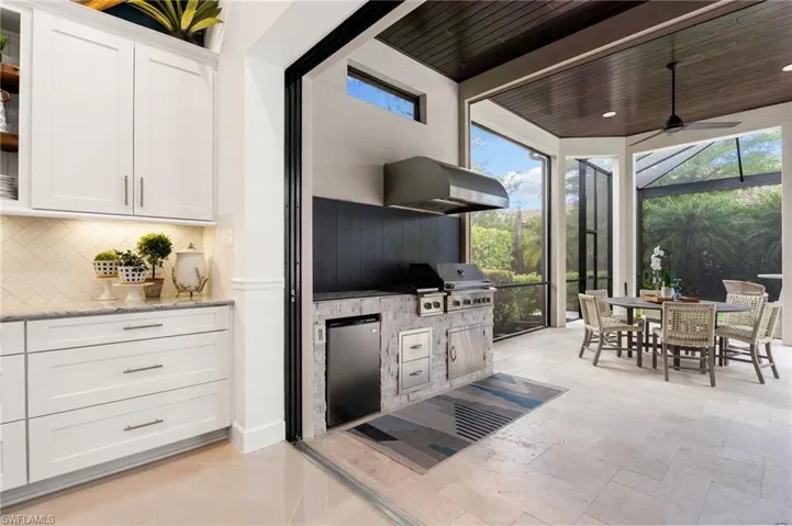 View of patio / terrace with a ceiling fan, a sunroom, area for grilling, outdoor dining space, and a lanai