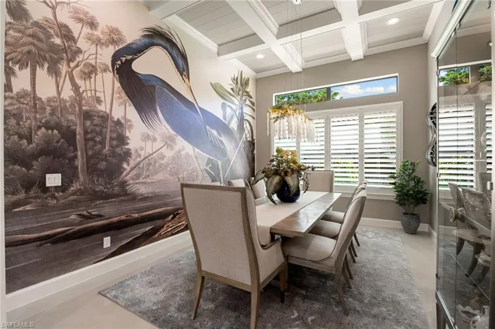 Tiled dining space with beamed ceiling, ornamental molding, coffered ceiling, recessed lighting, and a chandelier