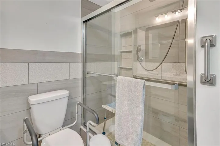 Bathroom with a stall shower and tile walls