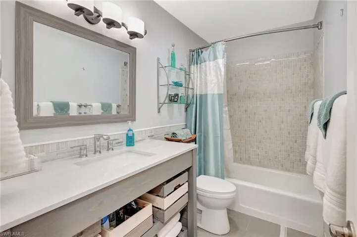Full bathroom featuring vanity, shower / tub combo, and tile patterned flooring
