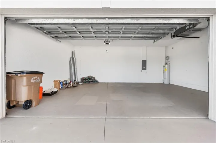 Garage featuring electric panel and water heater
