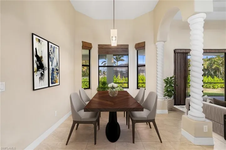 Dining room featuring ornate columns and light tile patterned flooring