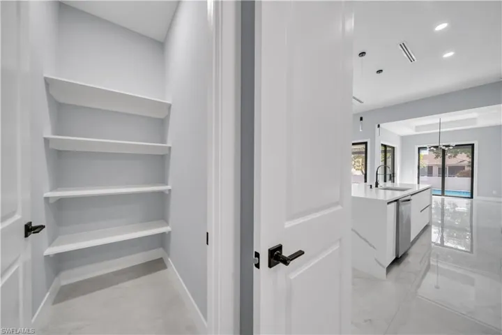 Corridor featuring light marble finish floors and recessed lighting