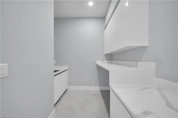 Bathroom featuring vanity and light marble finish floors
