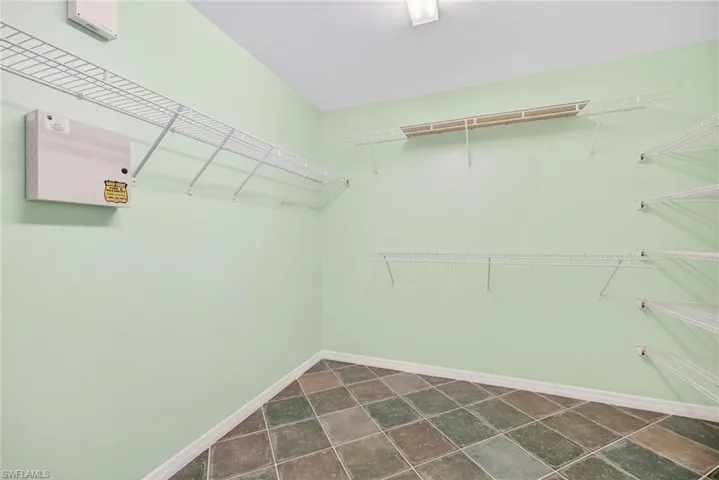 Walk in closet with dark tile patterned floors
