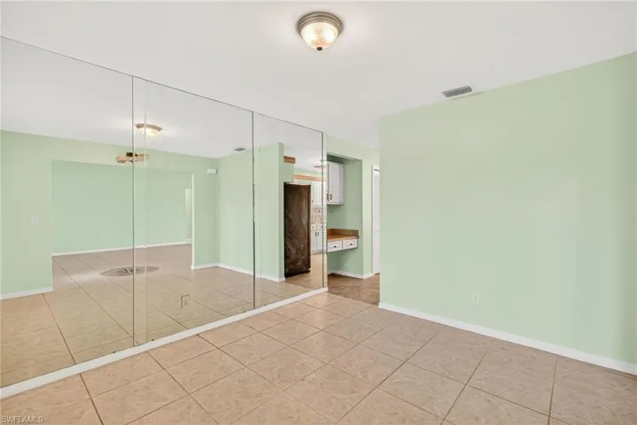 Unfurnished bedroom featuring light tile patterned flooring and a closet