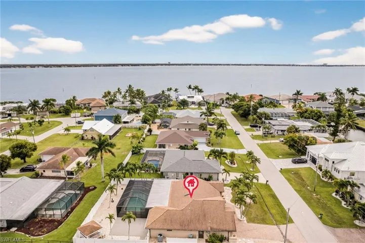 Aerial perspective of suburban area featuring a nearby body of water