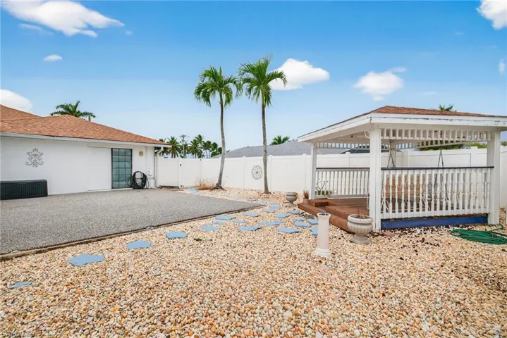 Fenced backyard featuring a gazebo