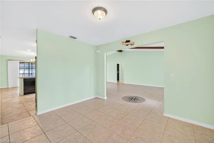 Unfurnished room with light tile patterned floors and baseboards