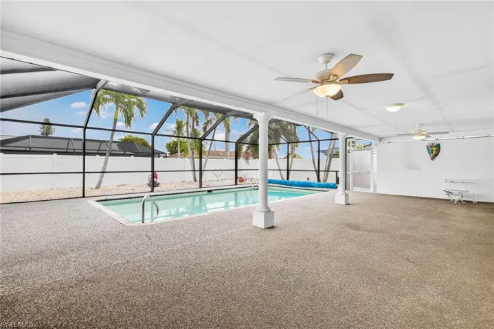 View of swimming pool featuring a lanai, a sunroom, a patio area, and a ceiling fan