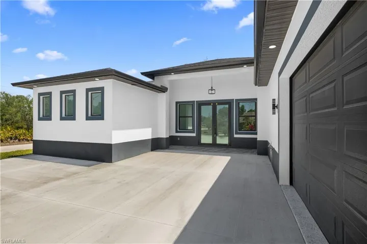 Property entrance featuring a garage and stucco siding