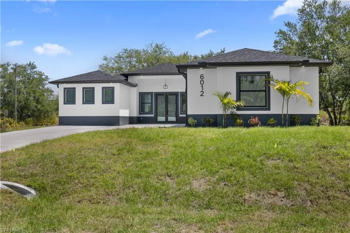 View of front of home with a shingled roof, french doors, a front lawn, and stucco siding