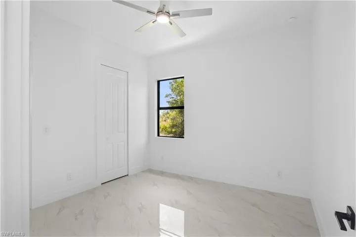 Empty room with a ceiling fan, baseboards, and marble finish floor